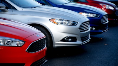 In this Nov. 19, 2015, photo, a row of new Ford Fusions are for sale on the lot at Butler County Ford in Butler, Pa.