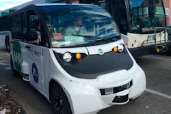 An autonomous shuttle bus, foreground, is seen Wednesday, May 15, 2019, in Olneyville Square in Providence, R.I.