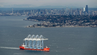 In this Feb. 23, 2018, file photo, a ship carrying four of the West Coast's largest container cranes passes through Puget Sound.