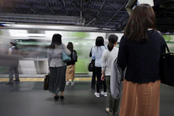 Commuters wait to get on a train at a station Wednesday, May 22, 2019, in Tokyo.