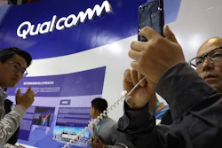 In this Nov. 6, 2018, file photo, attendees look at the latest technology from Qualcomm at the China International Import Expo in Shanghai.