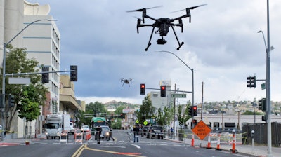 In this Tuesday, May 21, 2019 photo, two drones fly above Lake Street in downtown Reno, Nev.