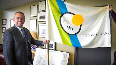In this Tuesday, May 21, 2019, photo, Spokane Mayor David Condon displays the city's flag in his office.