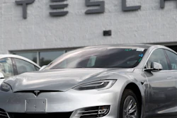 This July 8, 2018, photo shows Tesla 2018 Model 3 sedans on display outside a showroom in Littleton, Colo.