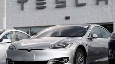 This July 8, 2018, photo shows Tesla 2018 Model 3 sedans on display outside a showroom in Littleton, Colo.