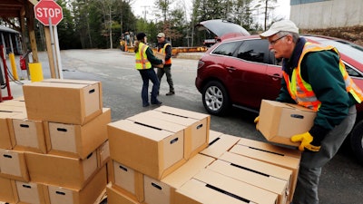 In this Monday, April 11, 2016, file photo, officials load boxes of bottled water in in Litchfield, N.H.