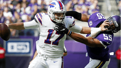 Buffalo Bills quarterback Josh Allen tries to break a tackle by Minnesota Vikings linebacker Anthony Barr during the first half of a game in Minneapolis, Sun., Sept. 23, 2018.