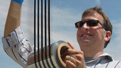 Thad Druffel, theme leader for solar manufacturing R&D at the University of Louisville's Conn Center for Renewable Energy Research, inspecting a printed roll of thin film solar cell material.