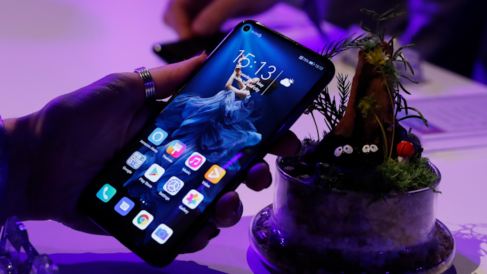 In this Tuesday, May 21, 2019, file photo, a member of the media tries out new Huawei Honor 20 series of phones following their global launch in London.