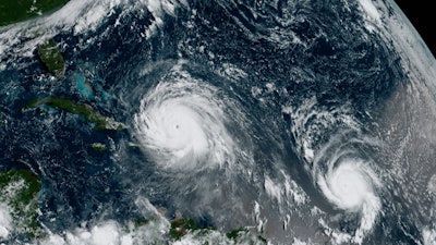 This Thursday, Sept. 7, 2017, satellite image shows the eye of Hurricane Irma, left, just north of the island of Hispaniola, with Hurricane Jose, right, in the Atlantic Ocean.
