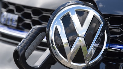 In this May 14, 2019, photo, an e-Golf car is fixed with a charging station at the Volkswagen plant in Zwickau, Germany.