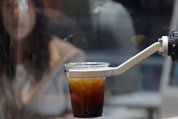 In this May 22, 2019, photo, a customer waits for a coffee in front of a robot named b;eat after placing an order at a cafe in Seoul.