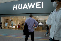 In this photo taken Monday, May 20, 2019, a man stands outside a Huawei store in Beijing.