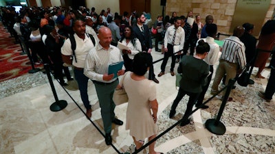 In this Tuesday, June 4, 2019, photo, job applicants line up at the Seminole Hard Rock Hotel & Casino Hollywood during a job fair in Hollywood, Fla.