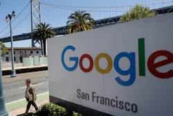 In this May 1, 2019, file photo, a man walks past a Google sign with a span of the Bay Bridge at rear in San Francisco.