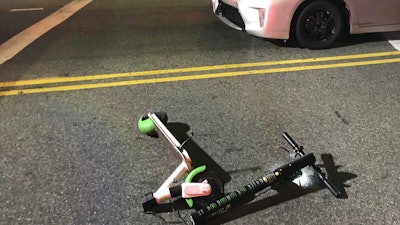 In this Dec. 23, 2018, photo provided by Jodi Robinson, a scooter Andrew Hardy was riding sits near the car that hit him in Los Angeles.