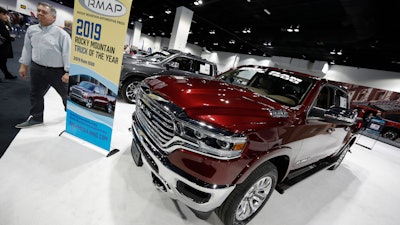 In this March 28, 2019, file photo, buyers look over a 2019 Ram pickup truck on display at the auto show in Denver.