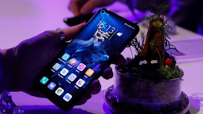 In this Tuesday, May 21, 2019, file photo, a member of the media tries out new Huawei Honor 20 series of phones following their global launch in London.