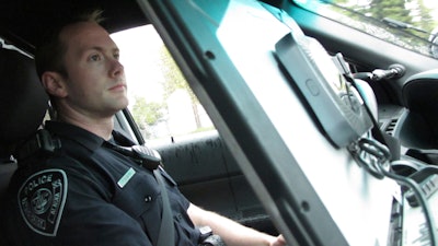 In this Wednesday, May 8, 2019, photo, Officer T. Scott Masten works a shift in Anchorage equipped with a wireless hotspot device on his patrol car laptop.