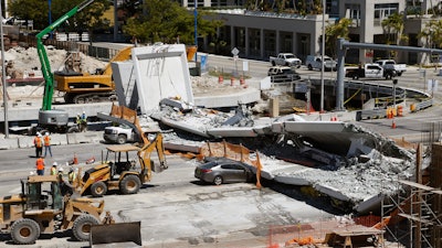 In this March 16, 2018, file photo, crushed cars are shown under a section of a collapsed pedestrian bridge near Florida International University.