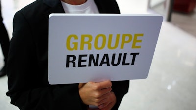A hostess holds a sign to show the way for the Renault shareholders general meeting in Paris, Wednesday, June 12, 2019.