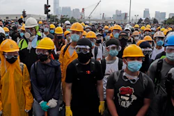 In this photo taken on Wednesday, June 12, 2019, protestors wear masks and helmets to protect their identities near the Legislative Council in Hong Kong.