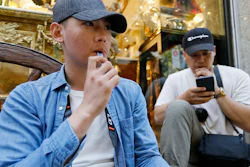 In this Monday, June 17, 2019, photo, Joshua Ni, 24, and Fritz Ramirez, 23, vape from electronic cigarettes in San Francisco.