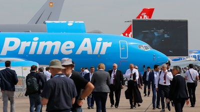 Visitors walk past a Boeing 737-800 BCF Amazon 'Prime Air' cargo plane at the Paris Air Show, Tuesday, June 18, 2019.
