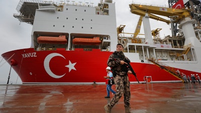 A police officer patrols near the drilling ship Yavuz at the port of Dilovasi, Turkey, Thursday, June 20, 2019.
