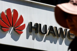 In this May 29, 2019, file photo, a woman walks by a Huawei retail store in Beijing.