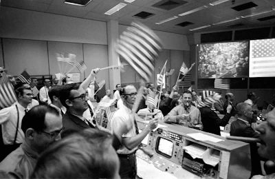 In this July 24, 1969 photo made available by NASA, flight controllers at the Mission Operations Control Room in the Mission Control Center at the Manned Spacecraft Center in Houston, celebrate the successful conclusion of the Apollo 11 lunar landing mission.