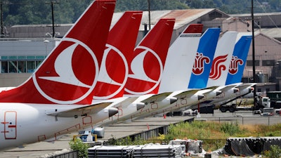 The tails of several grounded Boeing 737 Max airplanes line the edge of a parking area adjacent to Boeing Field, Thursday, June 27, 2019, in Seattle.