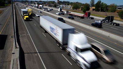 In this Wednesday, Aug. 24, 2016, file photo, truck and automobile traffic mix on Interstate 5, headed north through Fife, Wash., near the Port of Tacoma.