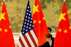 In this Feb. 14, 2019, file photo, Chinese staffers adjust U.S. and Chinese flags before the opening session of trade negotiations between U.S. and Chinese trade representatives at the Diaoyutai State Guesthouse in Beijing. Beijing on Friday, June 28, 2019, criticized what it calls 'negative content' about China in legislation before the U.S. Congress, saying it would further damage relations already roiled by disputes over trade and technology.