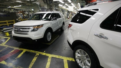 In this Dec. 1, 2010, file photo, plant employees drive 2011 Ford Explorer vehicles off the assembly line at Ford's Chicago Assembly Plant.