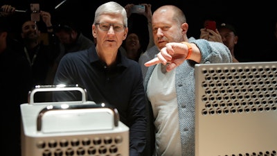 In this Monday, June 3, 2019 file photo, Apple CEO Tim Cook, left, and chief design officer Jonathan Ive look at the Mac Pro in the display room at the Apple Worldwide Developers Conference in San Jose, Calif. On Thursday, June 27, 2019, Apple said that Ive, chief design officer, will be leaving after more than two decades at the company to start his own firm.
