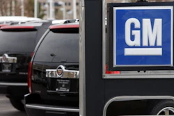 In this Sunday, Dec. 7, 2008, file photo, a GM sign in front of unsold 2009 Escalades at a Cadillac dealership in Lone Tree, Colo.