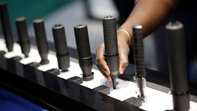 In this Jan. 19, 2016 file photo, gun silencers are on display at the Sig Sauer booth at the Shooting, Hunting and Outdoor Trade Show in Las Vegas. Gun silencers like the one used in a recent lethal shooting in Virginia Beach would be banned under legislation that U.S. Sen. Bob Menendez of New Jersey introduced Friday, June 21, 2019.