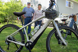 In this June 8, 2019 photo, Gordon and Janice Goodwin show their electric-assist bicycles outside their home in Bar Harbor, Maine. The bikes are banned on carriage roads and bicycle paths in nearby Acadia National Park.