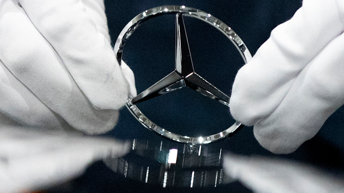In this Wednesday, April 3, 2019, file photo, a worker wipes a logo of a car at the Mercedes Benz automobile assembly plant outside Moscow.