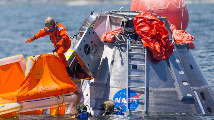 In this July 13, 2017, file photo, NASA astronaut Mike Fincke jumps into a life raft from an Orion capsule off Galveston Island, Texas.