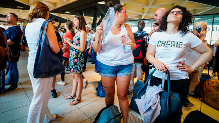Passengers check train times at Naples' Central station, southern Italy, Monday, July 22, 2019.