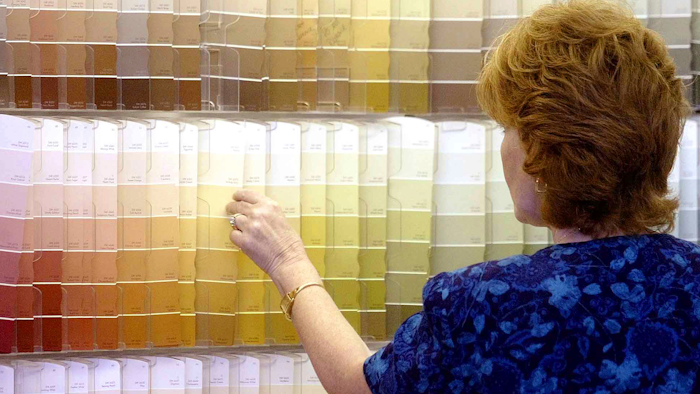 In this June 28, 2004, file photo, a customer looks over color chips at a Sherwin-Williams store in Columbus, Ohio. The nation's major suppliers of lead paint have agreed to pay California's largest cities and counties $305 million to settle a nearly two-decade old lawsuit. The settlement announced Wednesday, July 17, 2019, comes after years of legal and legislative battling in California and other states. The settlement is with the Sherwin-Williams Company, ConAgra Grocery Products Company and NL Industries, Inc.