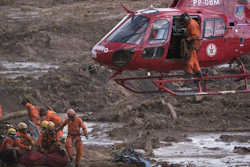 In this Jan. 28, 2019, file photo, firefighters prepare a body to be lifted away by a helicopter, after pulling the dead person from the mud days after a dam collapse in Brumadinho, Brazil.