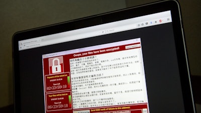 In this May 13, 2017, file photo, a screenshot of the warning screen from a purported ransomware attack, as captured by a computer user in Taiwan, is seen on laptop in Beijing.