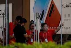 Staffers help a tourist search for directions at a Huawei retail store in Beijing, Tuesday, June 11, 2019.