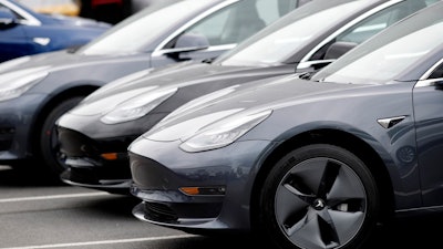 In this Sunday, May 19, 2019, file photo, a line of unsold 2019 Model 3 sedans sits at a Tesla dealership in Littleton, Colo.