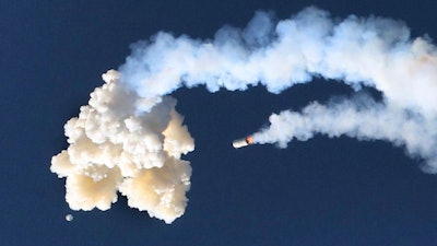 The Orion test capsule, bottom left, and a Minotaur 4 booster rocket, center, fall to the Earth, Tuesday, July 2, 2019.