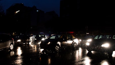 In this June 16, 2019, file photo, cars drive through an unlit street during a blackout in Buenos Aires.