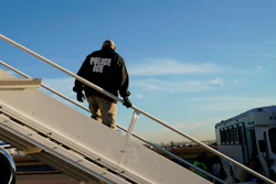 In this Nov. 16, 2018, file photo, an officer watches as immigrants who entered the United States illegally are deported on a flight to El Salvador by U.S. Immigration and Customs Enforcement in Houston.